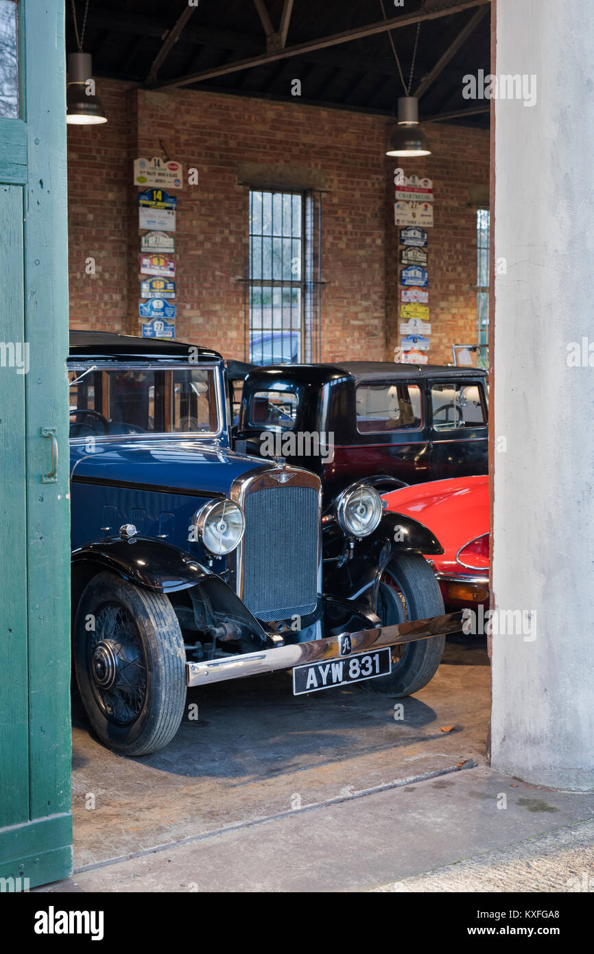 Vintage cars including a 1934 Austin in a garage at Bicester Heritage centre. Bicester, Oxfordshire, England. Stock Photo