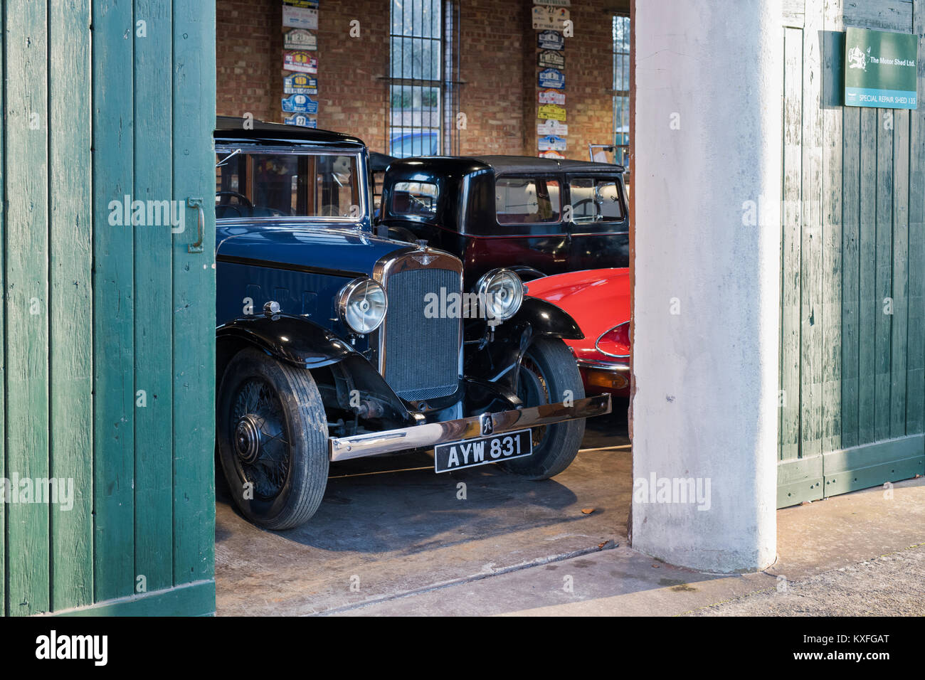 Vintage cars in a garage at Bicester Heritage centre. Bicester, Oxfordshire, England. Stock Photo