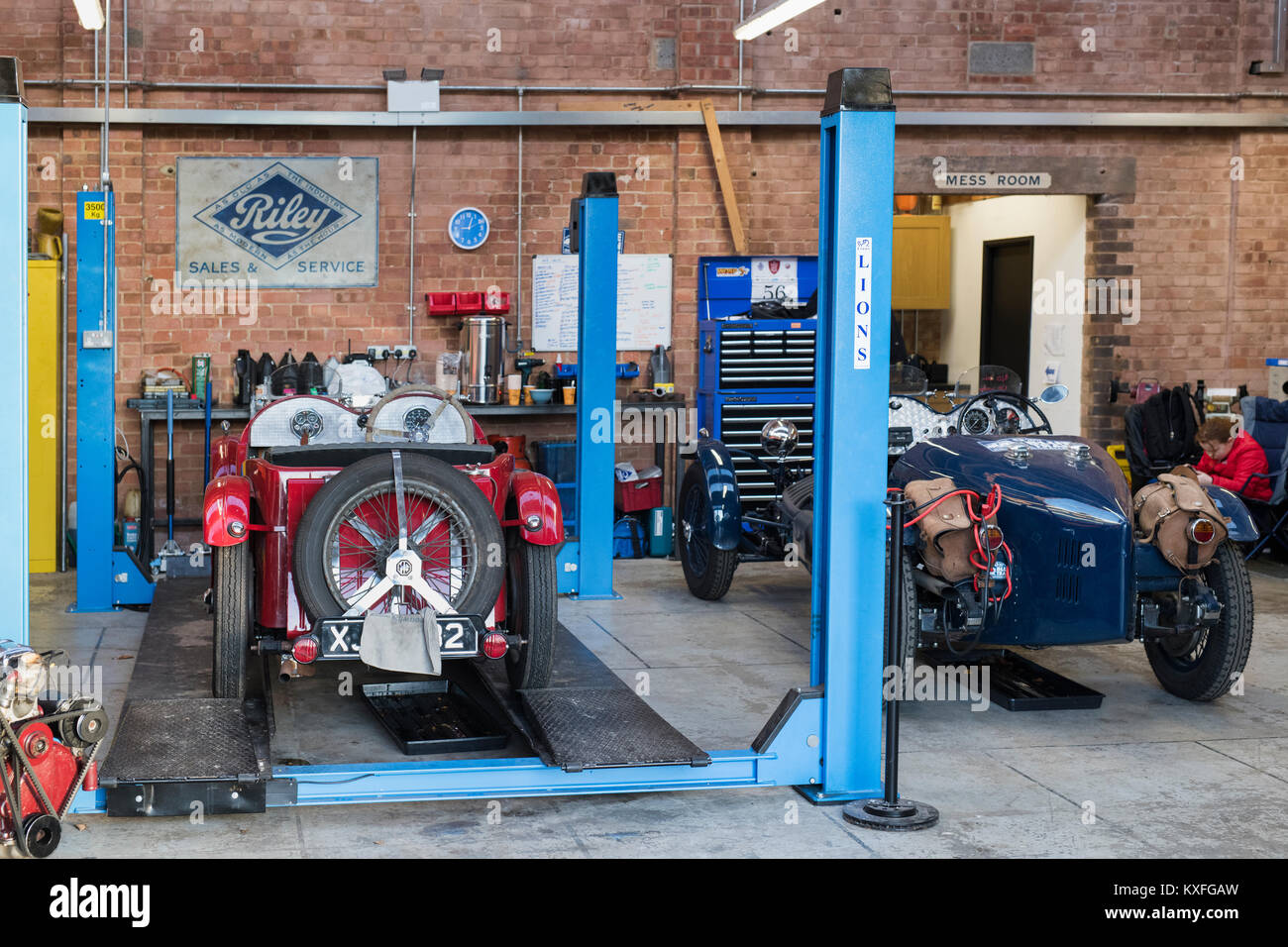 Vintage cars in a garage at Bicester Heritage centre. Bicester, Oxfordshire, England. Stock Photo