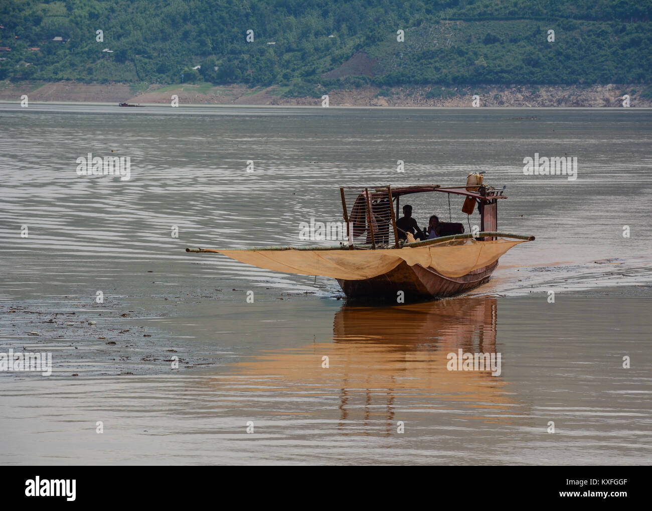 Hoa Binh, Vietnam - May 27, 2016. A wooden boat running on Da River in Hoa Binh, Northern Vietnam. The Da (Black) River is the most important tributar Stock Photo
