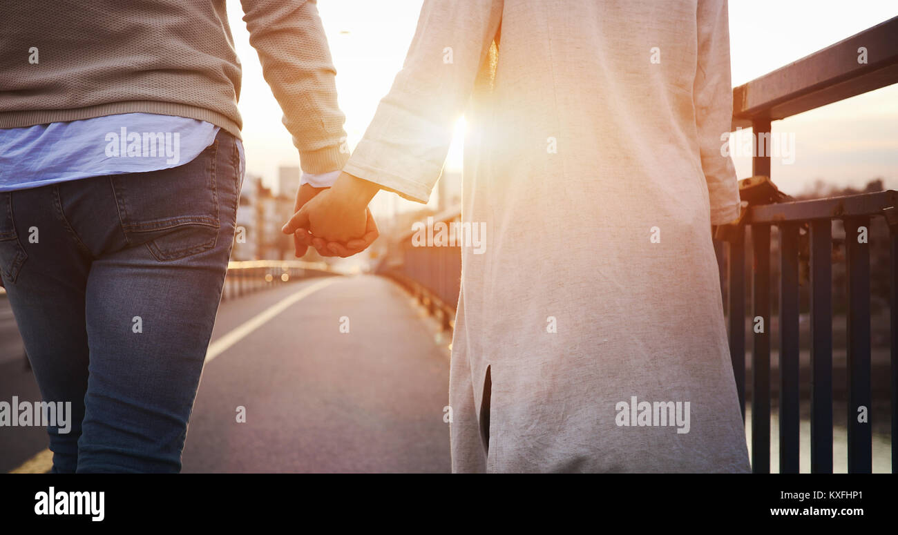 Happy couple holding hands in the sunset Stock Photo - Alamy