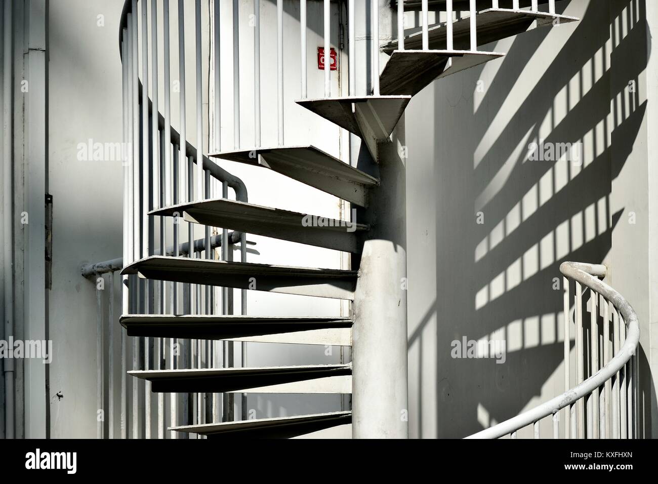 Elegant metal exterior spiral staircase on the side of a house in Singapore Stock Photo