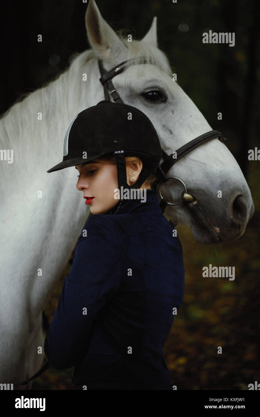 White horse lies its head on woman's shoulder. Stock Photo