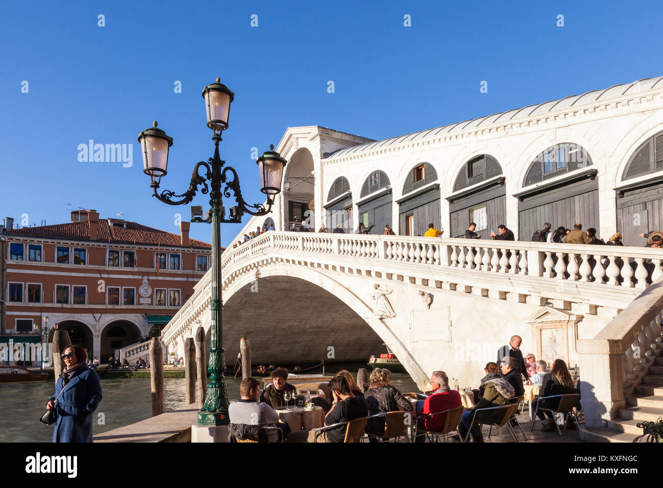 Tourists at an open air restaurant below Rialto Bridge, Grand Canal ...