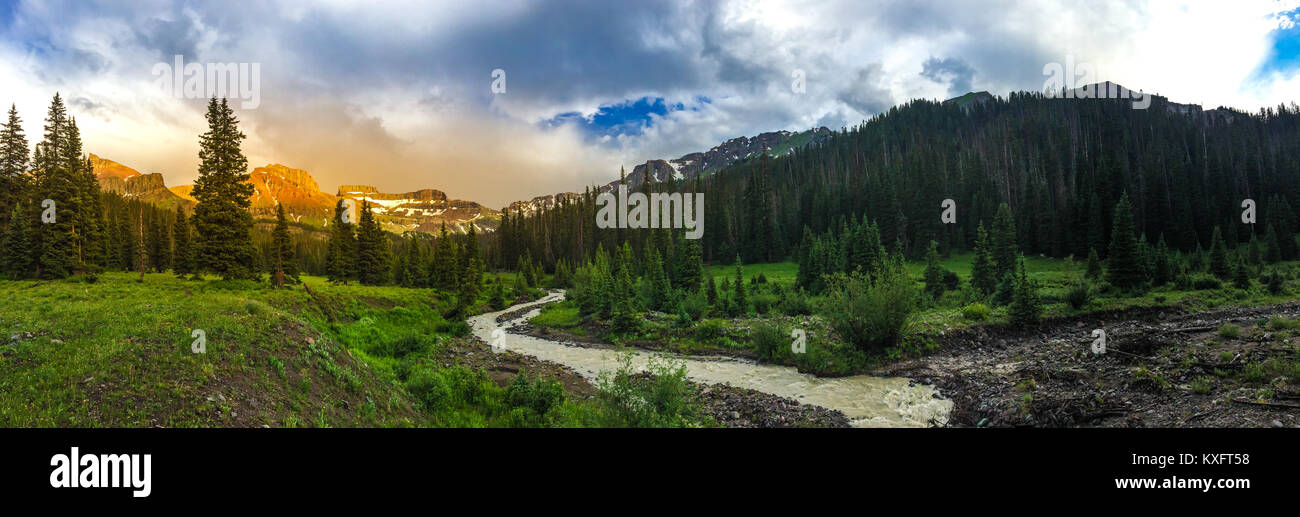 West Cimarron River with coxcomb redcliff and fortress mountains in the back at sunset panorama Stock Photo