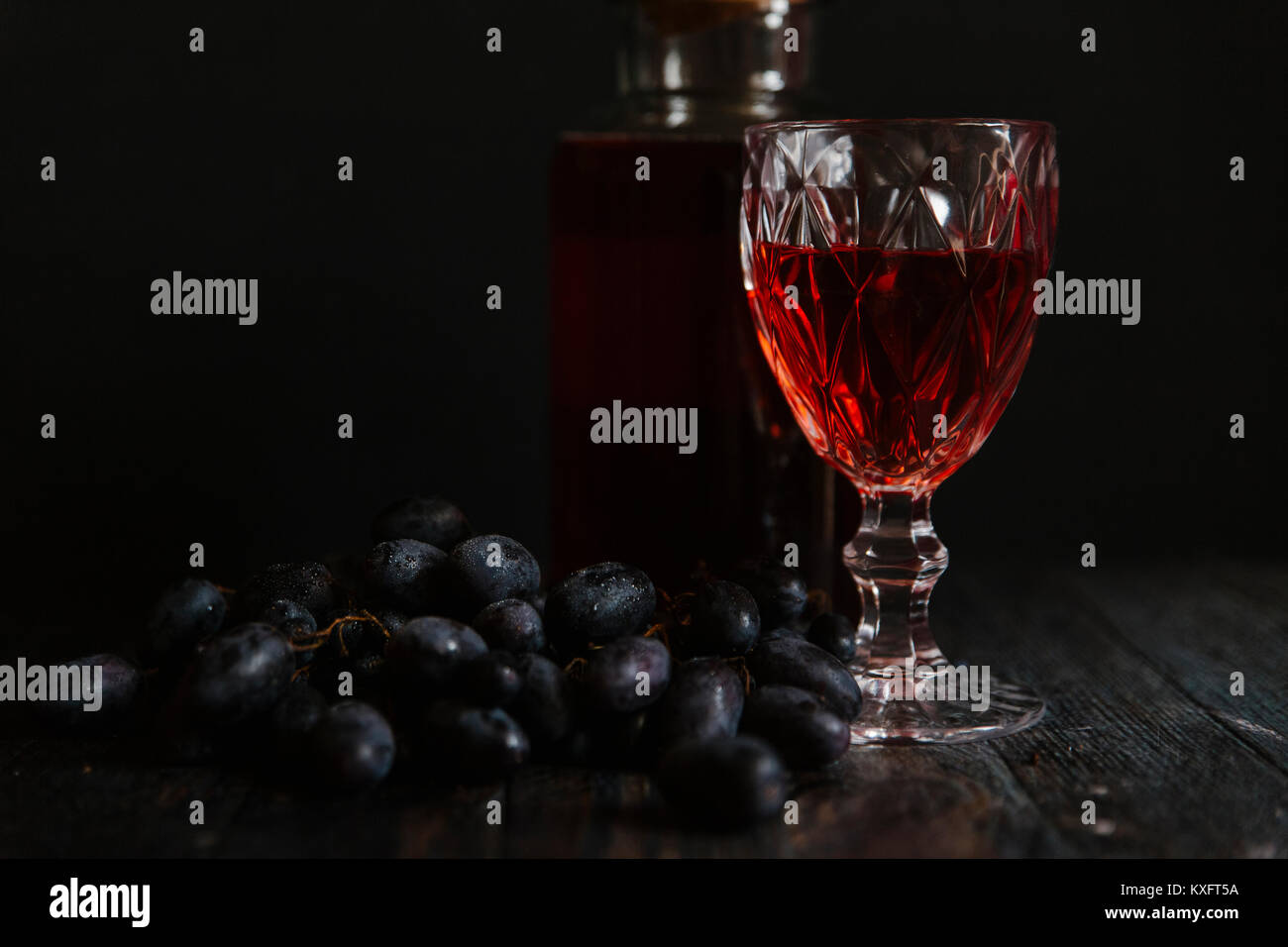 Red wine and grapes against black background Stock Photo