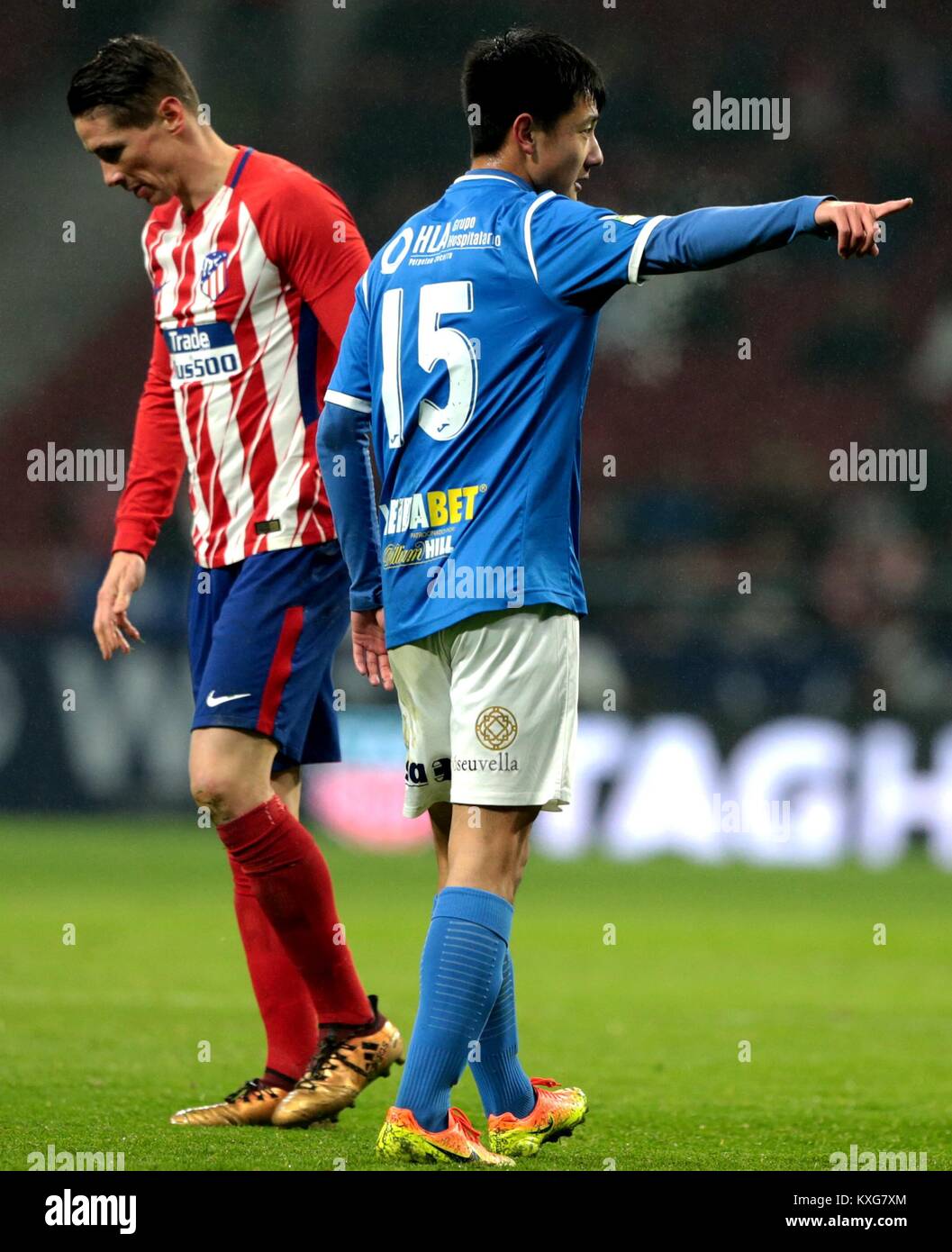 Madrid, Spain. 9th Jan, 2018. Lleida's Cheng Hui (R) gestures as Atletico Madrid's Fernando Torres passes by during the Spanish King's Cup round of 16 second leg match between Atletico Madrid and Lleida in Madrid, Spain, on Jan. 9, 2018. Atletico Madrid defeated Lleida with 3-0 and advanced to the quarterfinal with 7-0 on aggregate. Credit: Juan Carlos Rojas/Xinhua/Alamy Live News Stock Photo