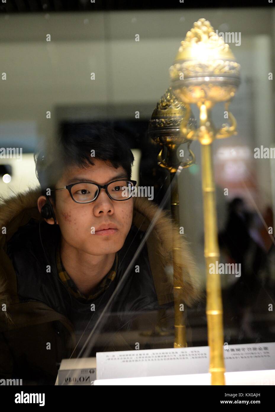 Xi'an, China's Shaanxi Province. 9th Jan, 2018. A visitor views exhibits displayed during an exhibition on cultural relics of ancient Chinese dynasties at Shaanxi History Museum in Xi'an, capital of northwest China's Shaanxi Province, Jan. 9, 2018. More than 600 cultural relics of four dynasties including Zhou (1046 B.C. - 256 B.C.), Qin (221 B.C. - 206 B.C.), Han (206 B.C.- 220 A.D.) and Tang (618-907) were displayed during the exhibition. Credit: Li Yibo/Xinhua/Alamy Live News Stock Photo