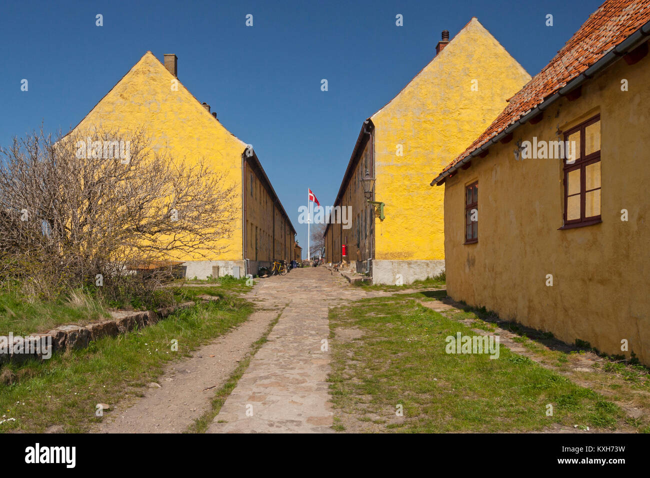 Yellow residential buildings and The Street (Gaden) on Christiansø, Ertholmene, Bornholm, Denmark Stock Photo