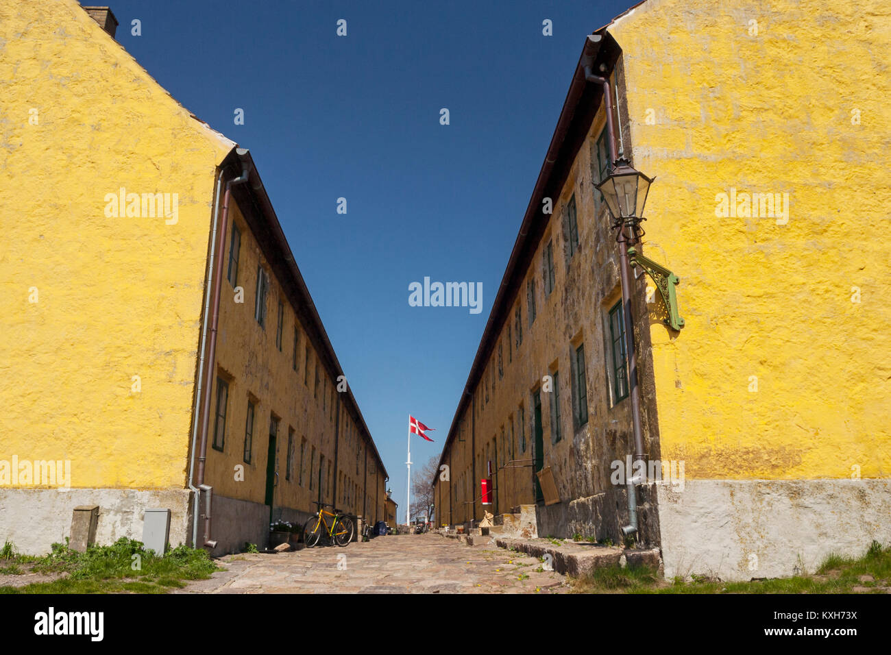 Yellow residential buildings and The Street (Gaden) on Christiansø, Ertholmene, Bornholm, Denmark Stock Photo