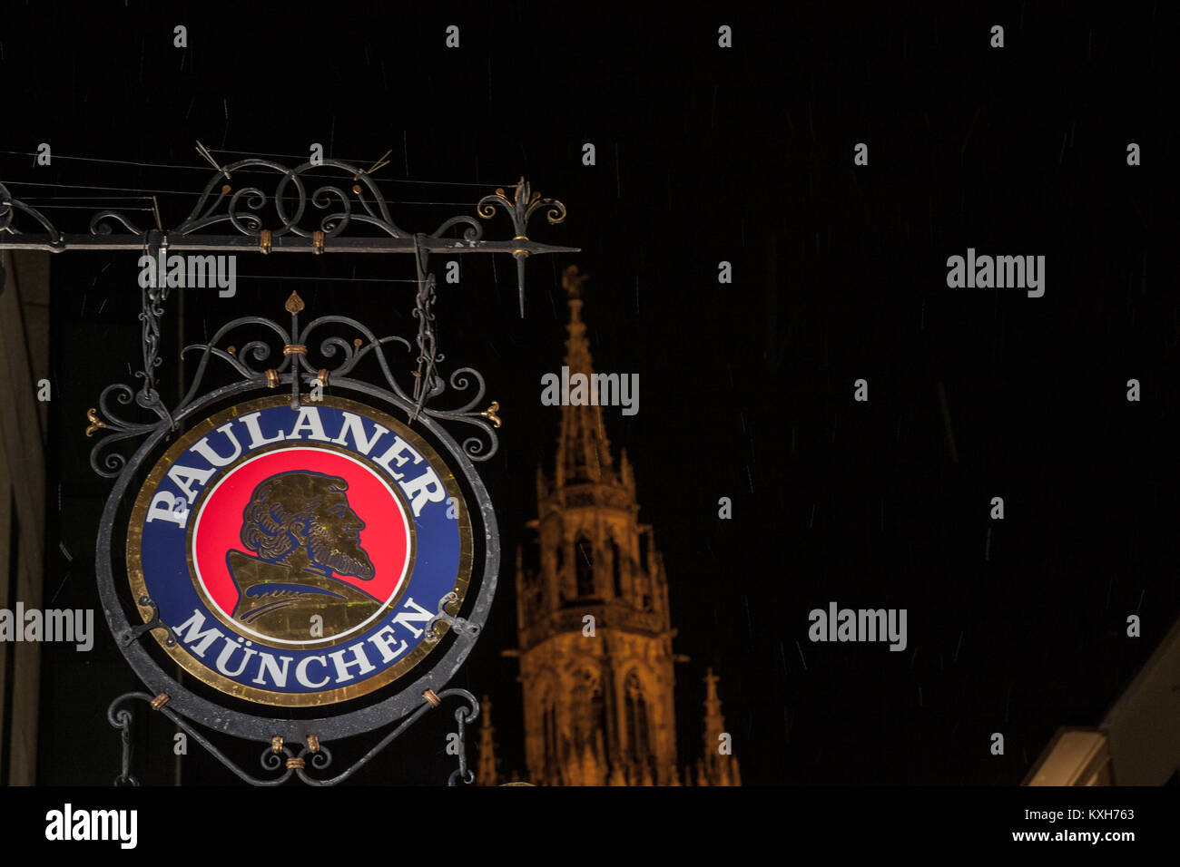 MUNICH, GERMANY - DECEMBER 17, 2017: Paulaner Beer logo in front of Munich New Town Hall (Neues Rathaus) at night. Paulaner Bier is one of the symbols Stock Photo