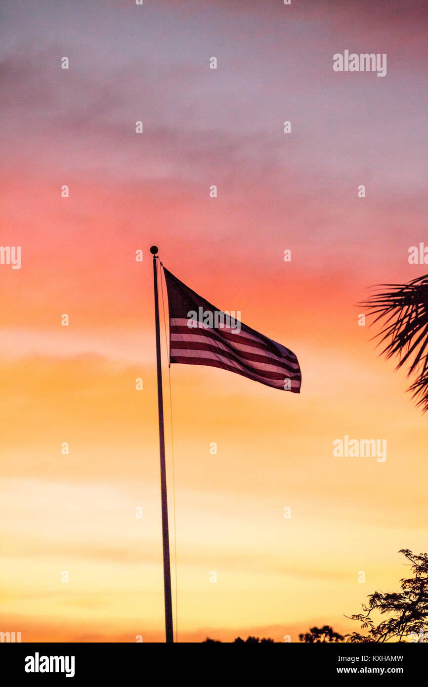Red, white and blue American flag blows in the wind  at sunrise Stock Photo