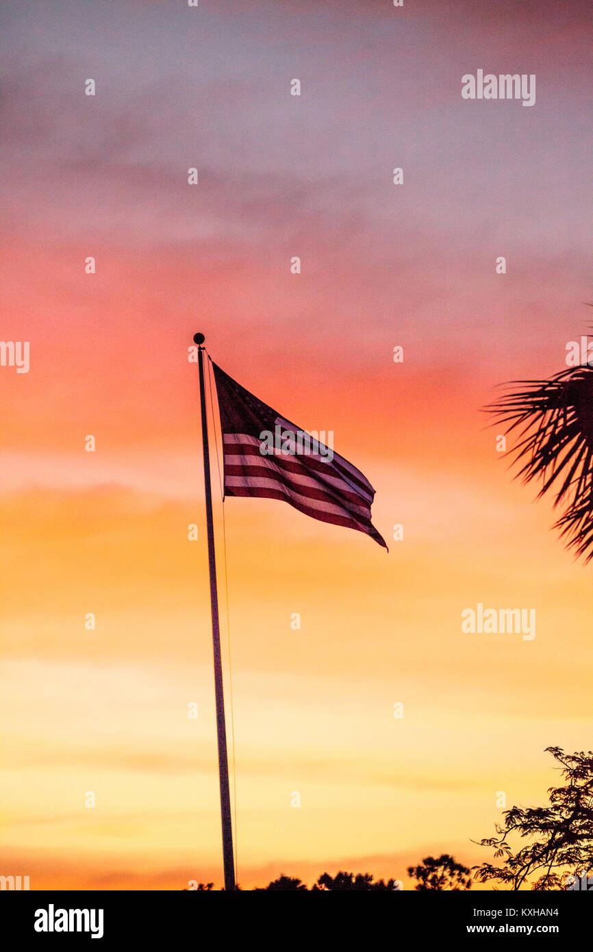 Red, white and blue American flag blows in the wind  at sunrise Stock Photo