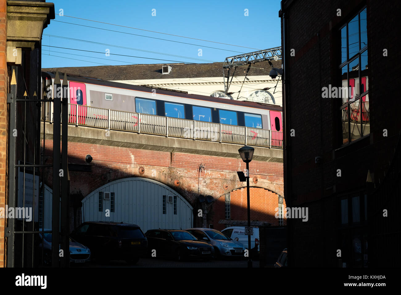 A CrossCounty train passing over shops and buildings on an elevate rail track in Leeds city centre, Yorkshire, UK Stock Photo