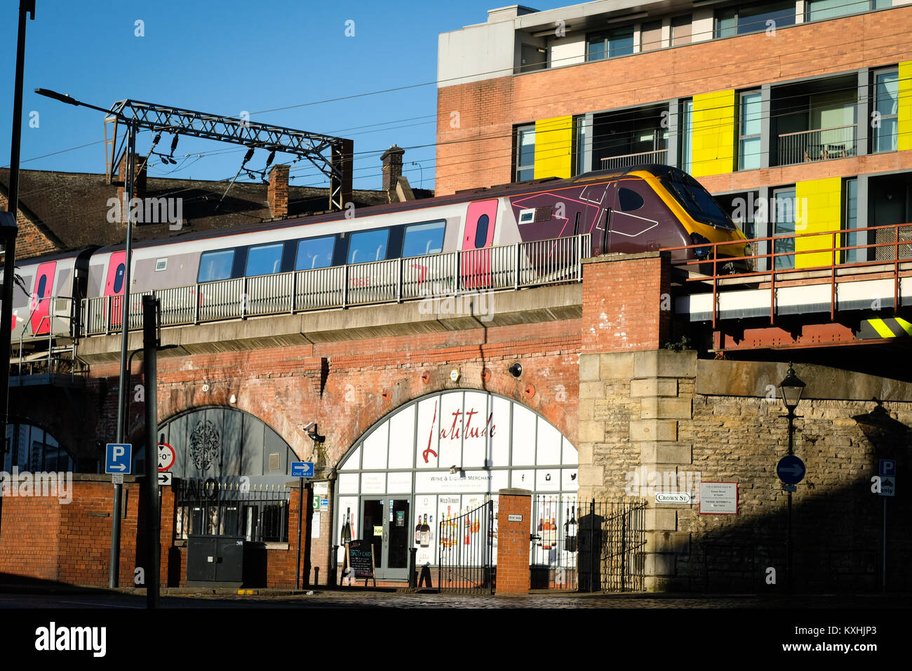 A CrossCounty train passing over shops and buildings on an elevate rail track in Leeds city centre, Yorkshire, UK Stock Photo