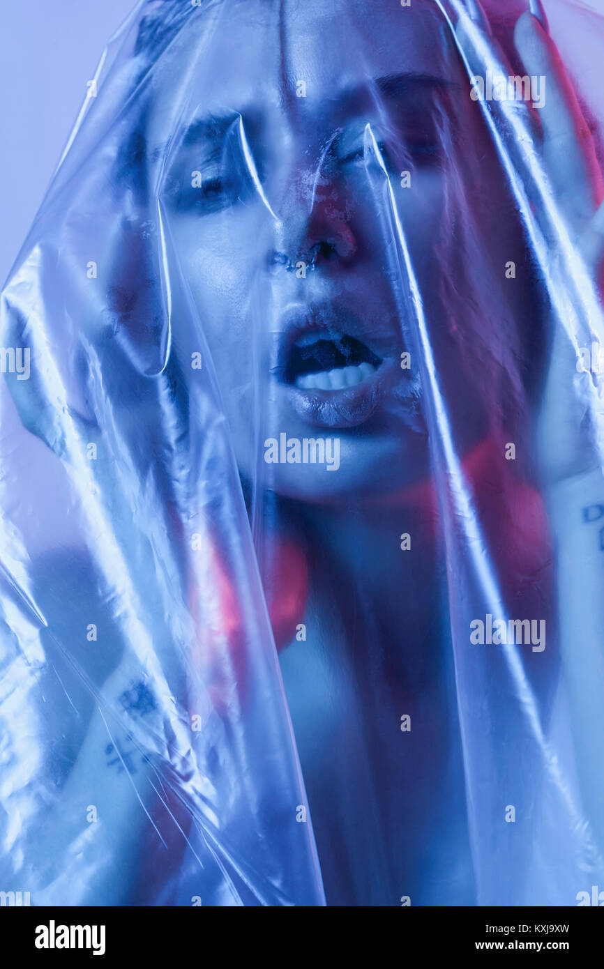 Close-up portrait of sensuous young woman wrapped in plastic Stock Photo