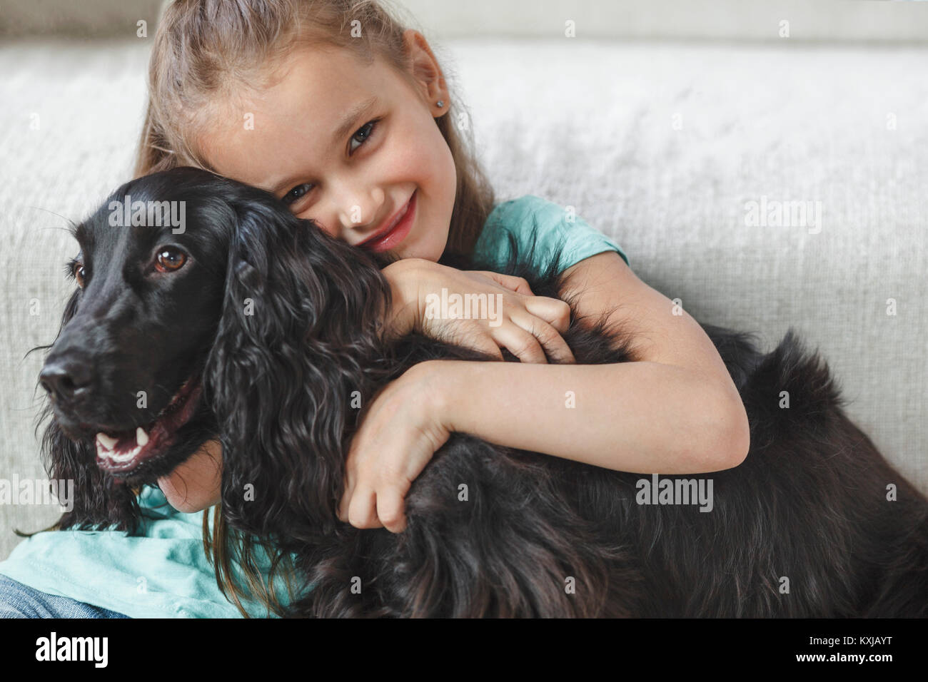 Portrait of smiling girl embracing dog at home Stock Photo