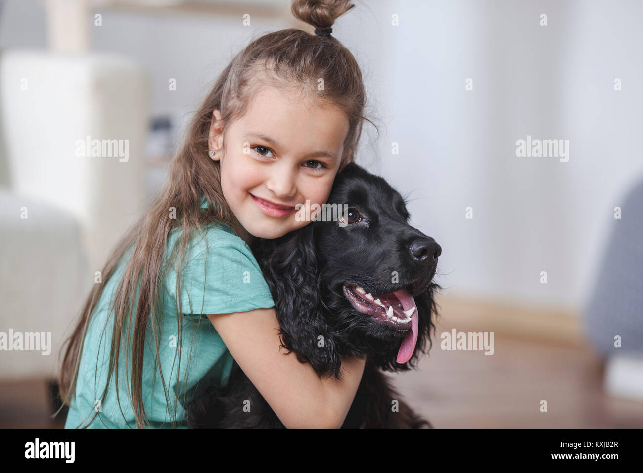 Portrait of smiling girl embracing Cocker Spaniel at home Stock Photo
