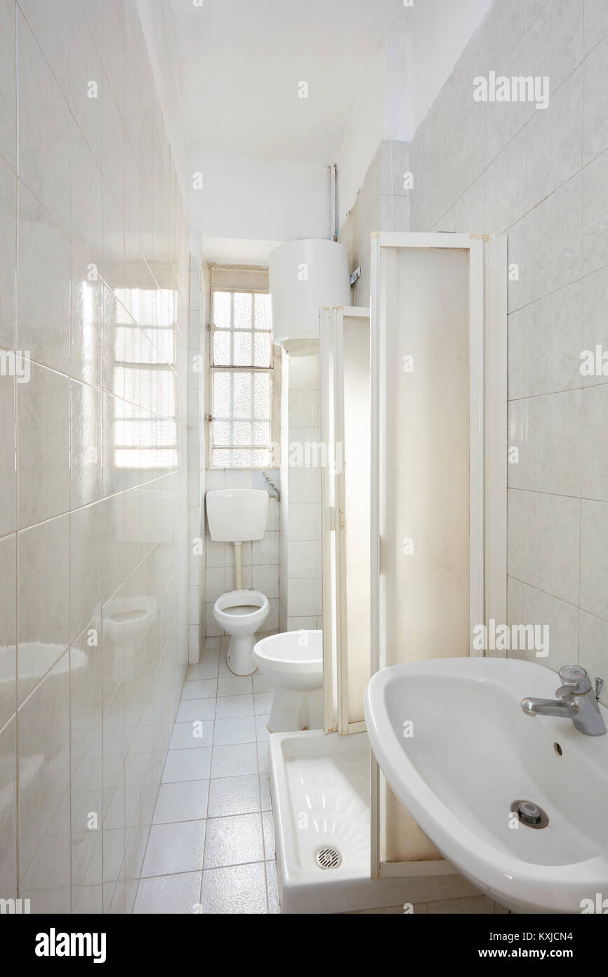 Old bathroom interior with tiled floor and walls Stock Photo