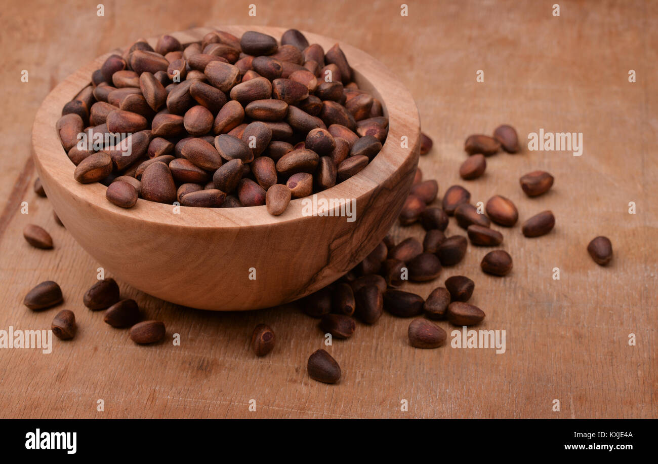 Bowl of cedar nuts on wooden background Stock Photo