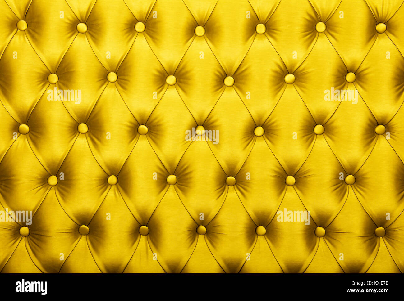 Yellow vivid capitone textile background, retro Chesterfield style checkered soft tufted fabric furniture diamond pattern decoration with buttons, clo Stock Photo