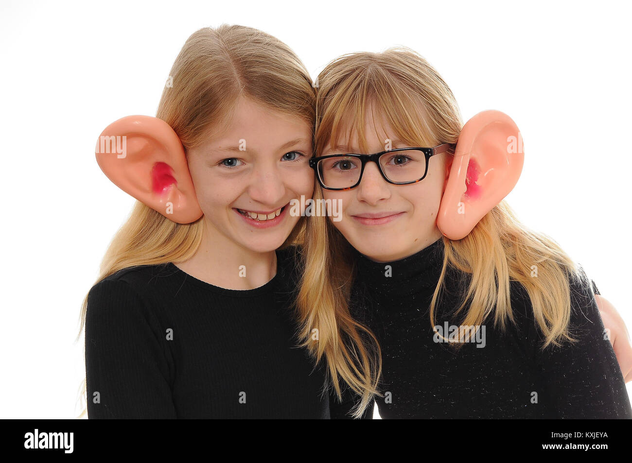 two pretty blonde Caucasian girls dressed up in large, false ears isolated on white Stock Photo