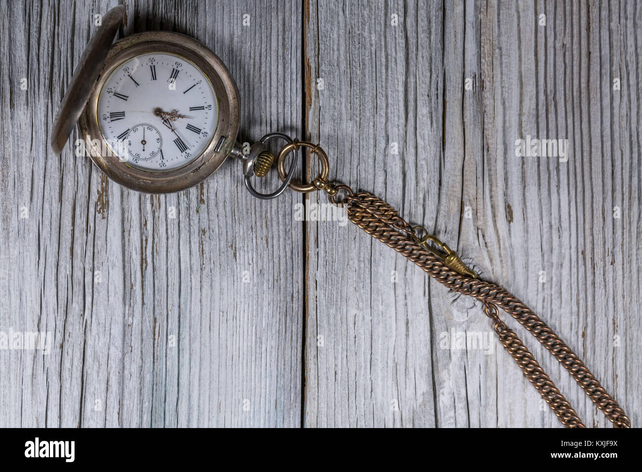 Image of an old antique pocket watch lying on an old rustic wood background Stock Photo