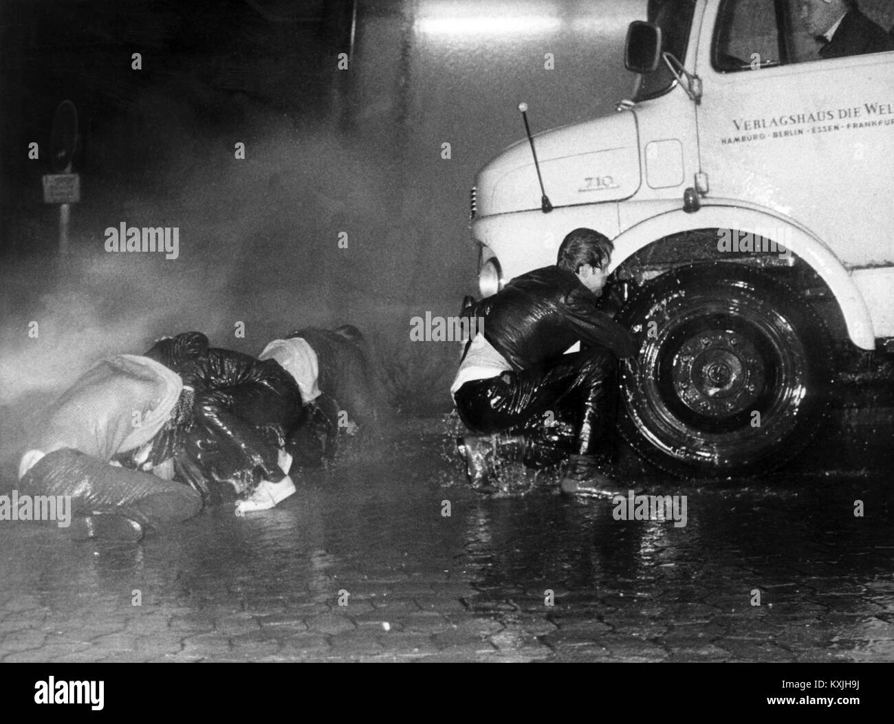 With a water cannon, the police are trying to clear a path for the newspaper cars. All exits of the Essen Springerhaus were blocked on Friday evening (12 April 1968) after 8 p. m. by several hundred demonstrators, most of whom had come from other university towns in the country. Several attempts by the police to allow newspaper cars to leave failed. Newspaper packages were torn down and burned from the delivery vans. | usage worldwide Stock Photo