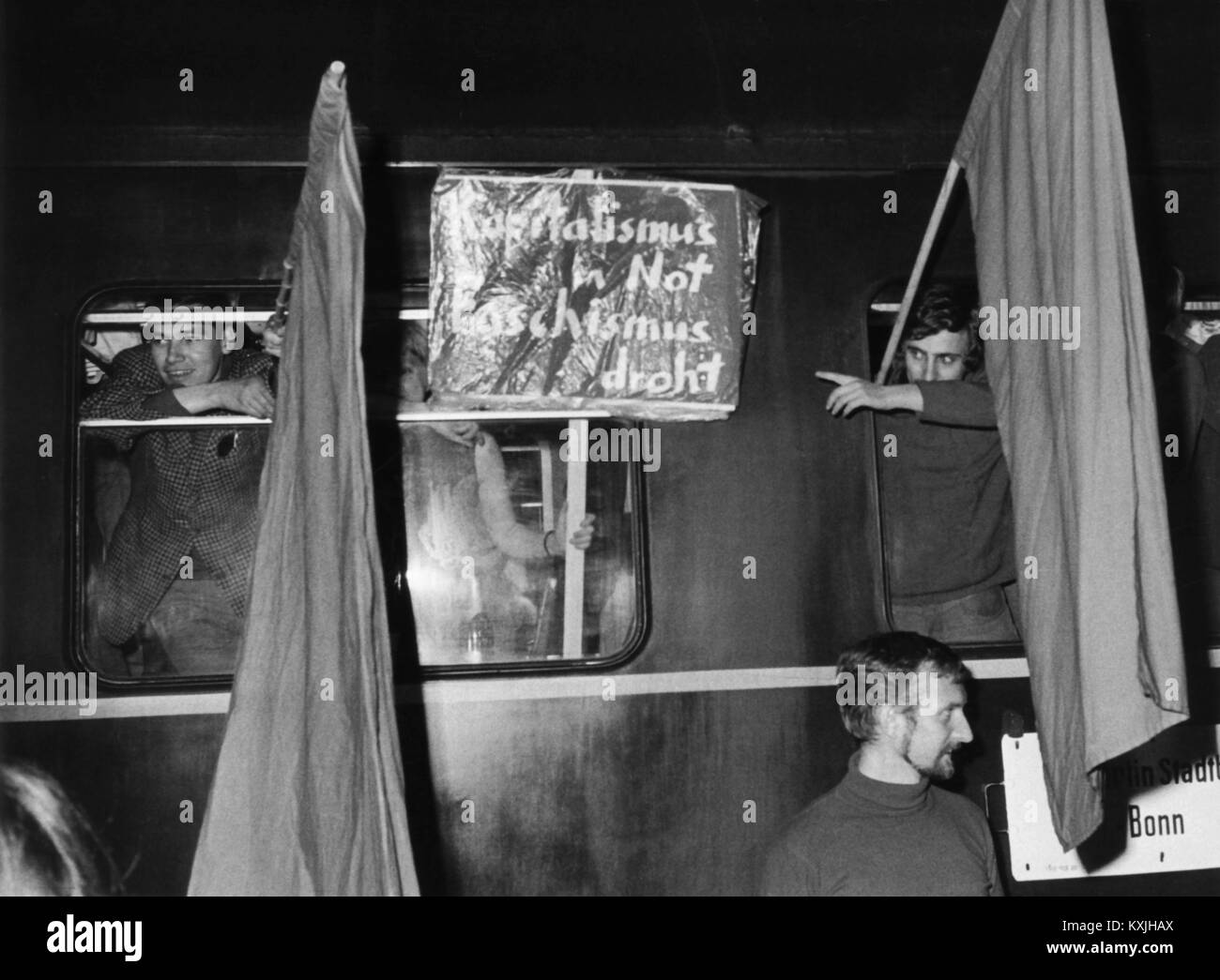 The special train at the border checkpoint Helmstedt. Demonstrators hold two red flags and a banner with the inscription "Capitalism in Misery - Fascism Threatens" from the compartment windows. On the evening of May 10,1968, a special train of the Deutsche Reichsbahn (GDR) left Friedrichstraße station in East Berlin to bring members of the Berlin SDS (Socialist German Student Union), the Berlin Communards and other demonstrators to Bonn for demonstrations against the German Emergency Acts. | usage worldwide Stock Photo