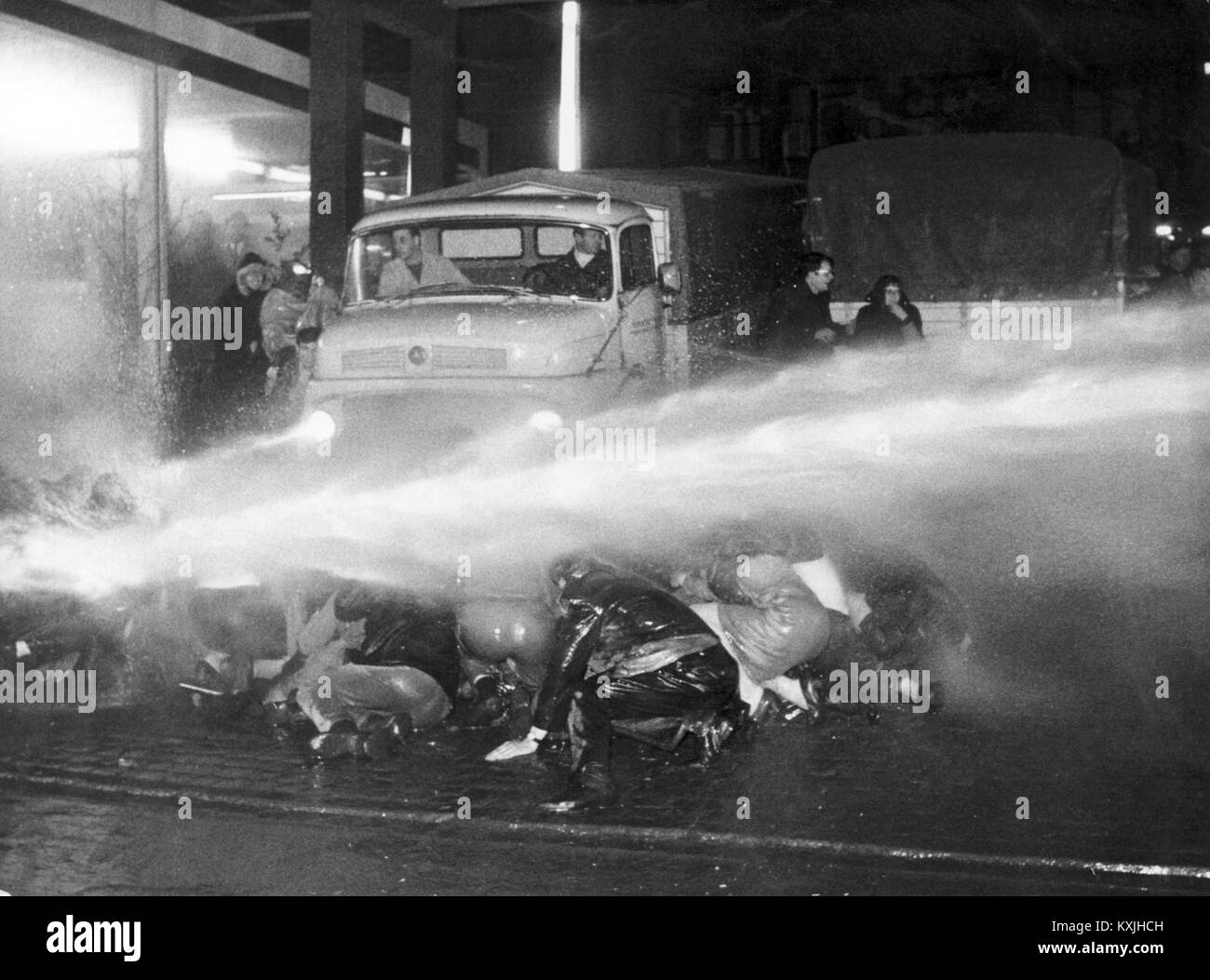 With a water cannon, the police are trying to clear a path for the newspaper cars. All exits of the Essen Springerhaus were blocked on Friday evening (12 April 1968) after 8 p. m. by several hundred demonstrators, most of whom had come from other university towns in the country. Several attempts by the police to allow newspaper cars to leave failed. Newspaper packages were torn down and burned from the delivery vans. | usage worldwide Stock Photo