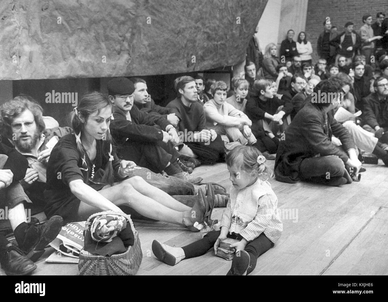 Students, including a young mother and her little girl, sit in the vestibule of the Technical University in Berlin on February 17,1968 during the 'International Vietnam Conference'. Almost 3,000 young people accepted the invitation of the Socialist German Student Union (SDS) and numerous left-wing socialist youth organizations. In the crowded Auditorium Maximum, the predominantly student audience gathered in front of a large Vietkong flag. Hundreds of participants had settled down in front of the hall due to a lack of space. | usage worldwide Stock Photo