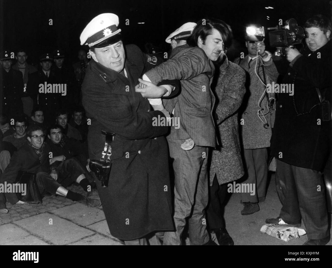A demonstrant is arrested in front of the America House in Munich on the 8th of February in 1968. There were riots shortly before the opening of an exhibition in the course of protests against Vietnam War. | usage worldwide Stock Photo