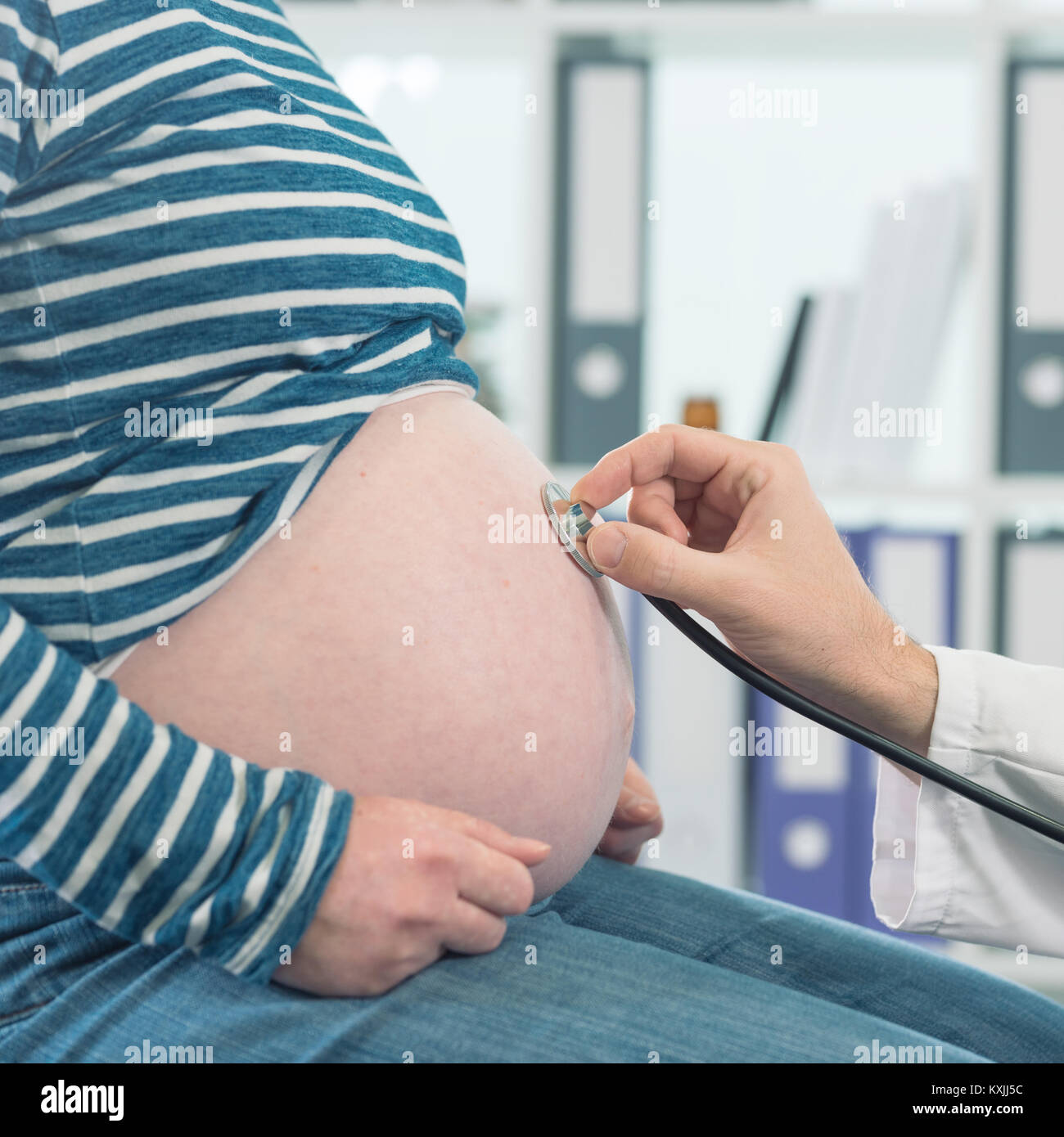 Doctor examining pregnant woman with stethoscope. Health care control during pregnancy. Stock Photo