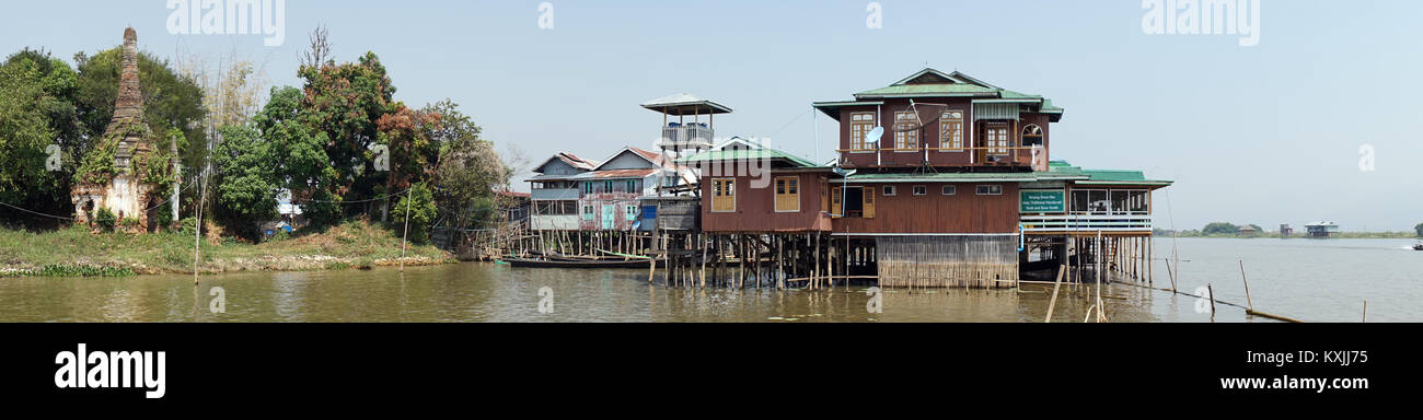 NYAUNGSHWE, MYANMAR - CIRCA APRIL 2017 Old brick stupa and wooden houses on the Inle lake Stock Photo