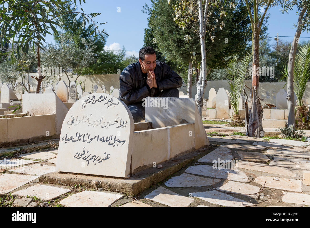 Jenin, Palestine, January 11, 2011: Ismail Khatib is praying on his sons Ahmad, grave, Ahmad was shot by Israeli Forces. He became symbol of peace. Stock Photo