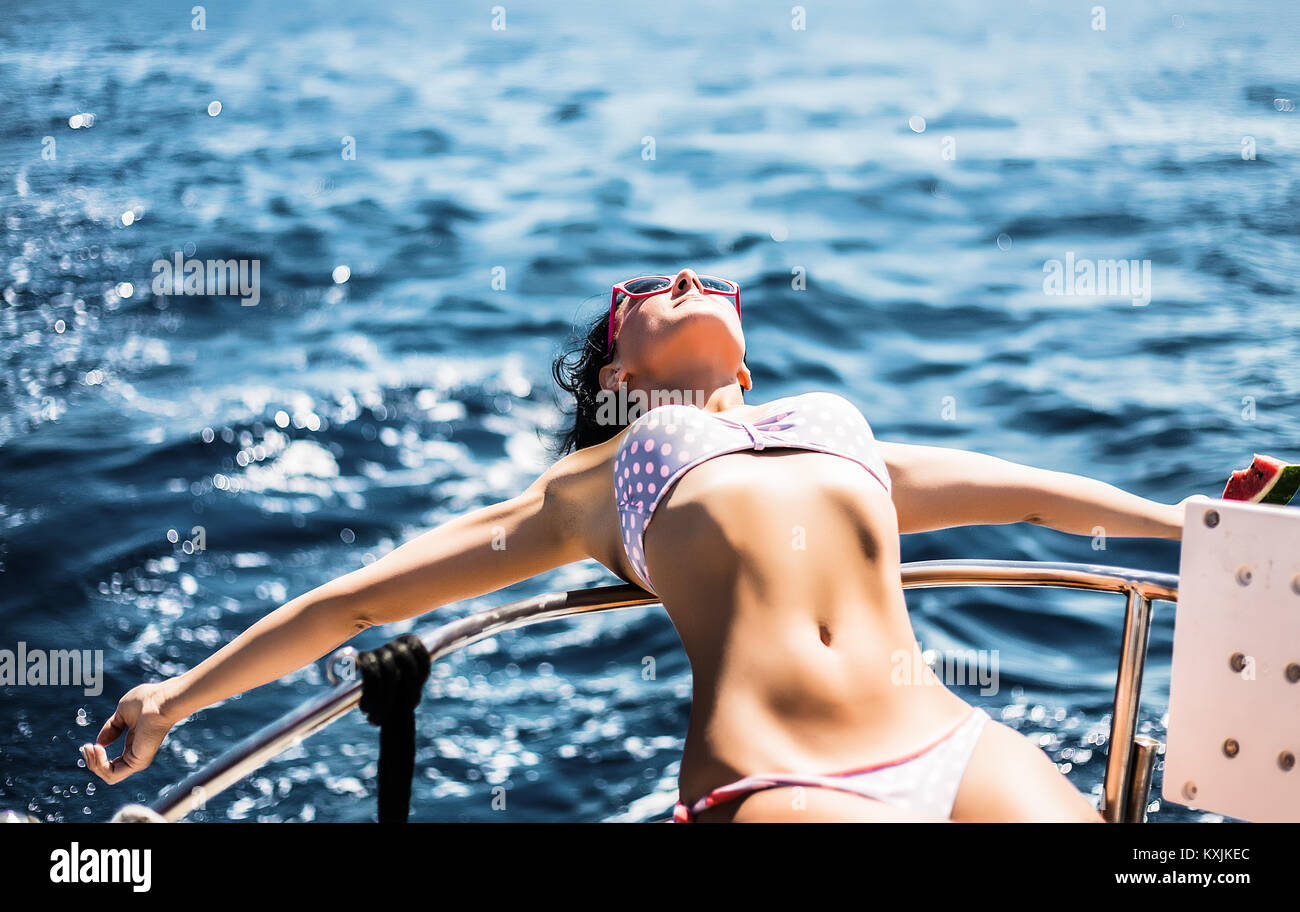 Woman in bikini enjoying sun and sea on boat Stock Photo