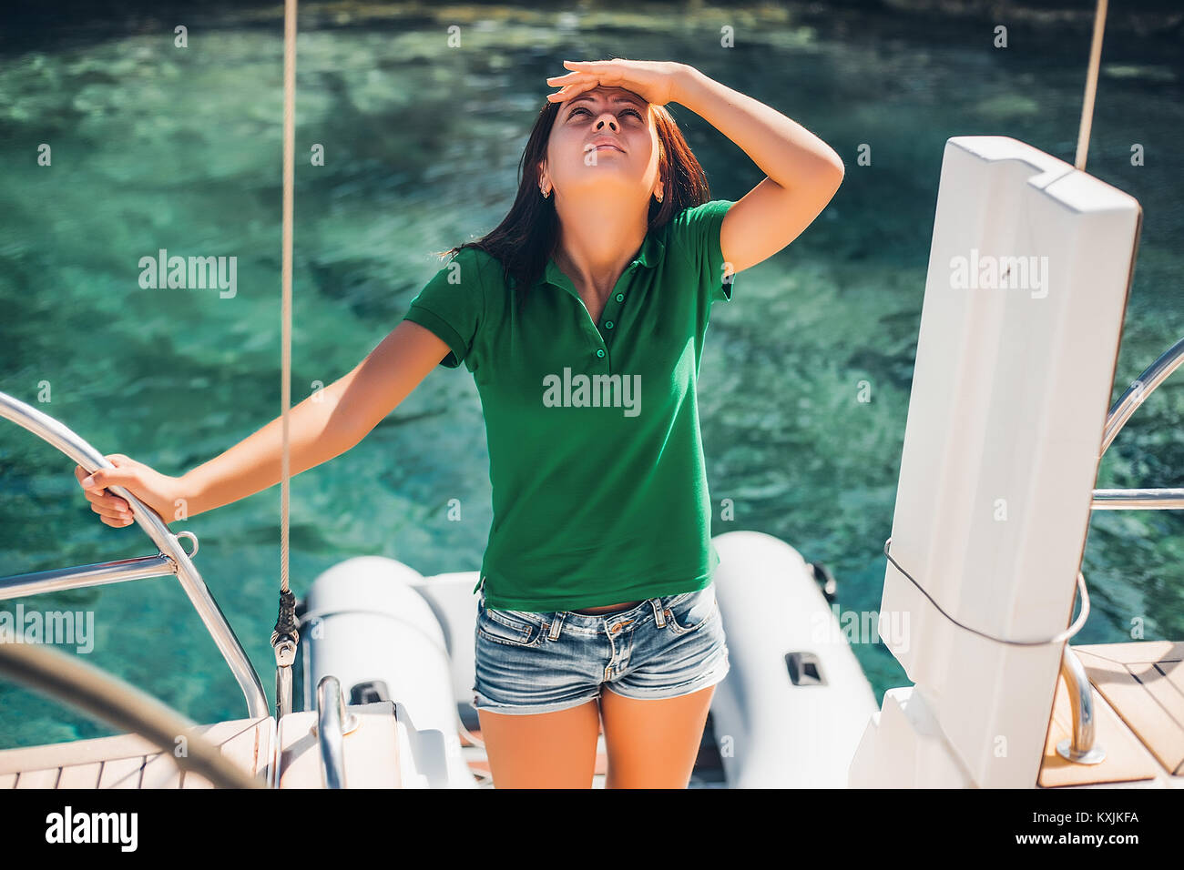 Woman on sailboat looking up at something Stock Photo