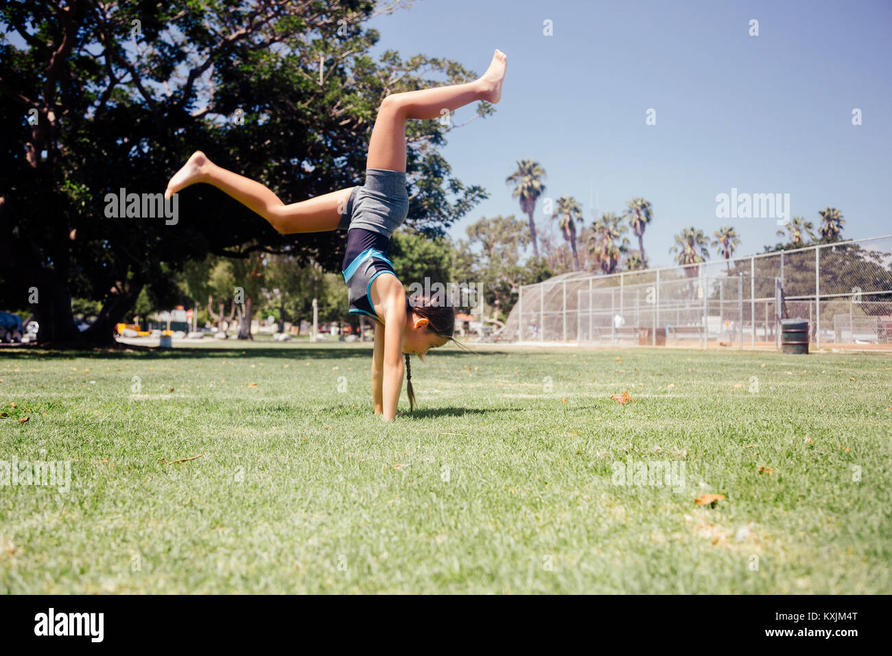 Schoolgirl doing cartwheel on school sports field Stock Photo Alamy