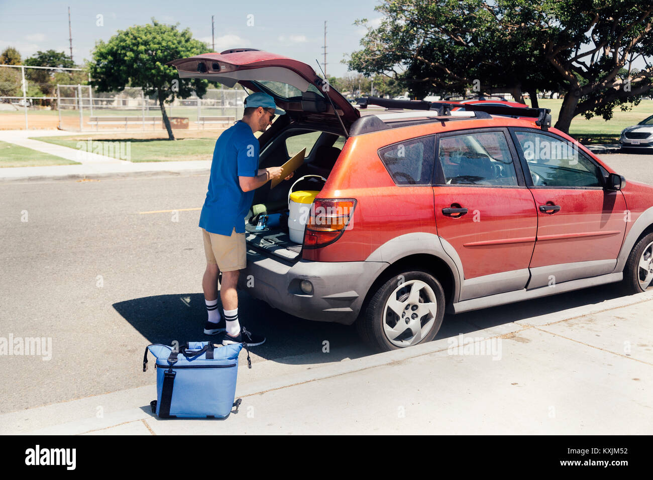Male sport teacher packing car boot at school Stock Photo