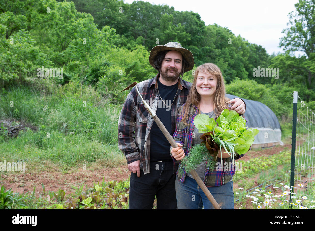 Couple in vegetable garden looking at camera smiling Stock Photo - Alamy