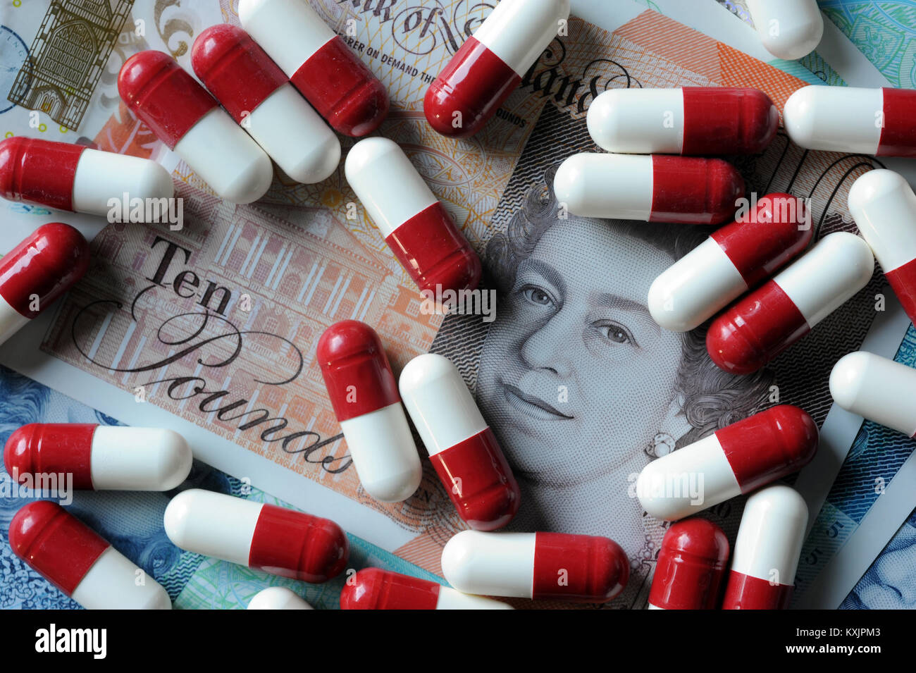 NEW BRITISH CURRENCY WITH MEDICATION CAPSULES RE COST OF HEALTHCARE PRESCRIPTIONS MEDICINE NHS GP DRUGS ETC UK Stock Photo