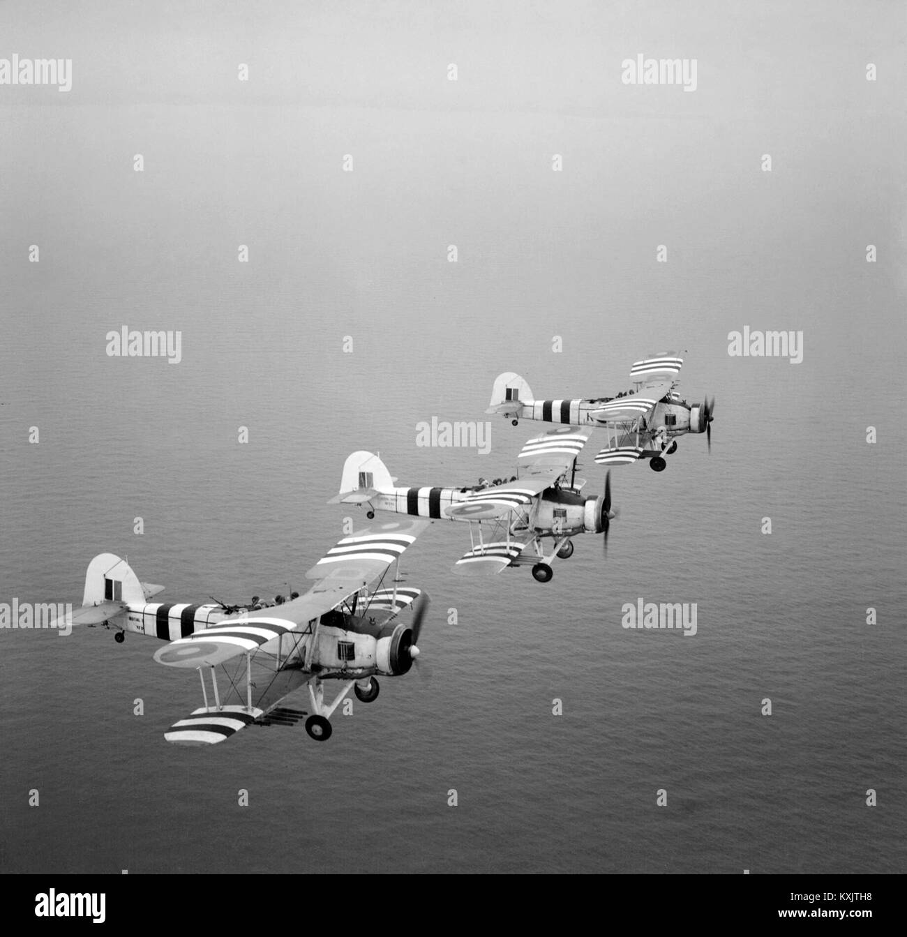 Three rocket-armed Swordfish on a training flight, August 1944. The aircraft are painted with Invasion stripes The Fairey Swordfish was a biplane torpedo bomber designed by the Fairey Aviation Company. Stock Photo