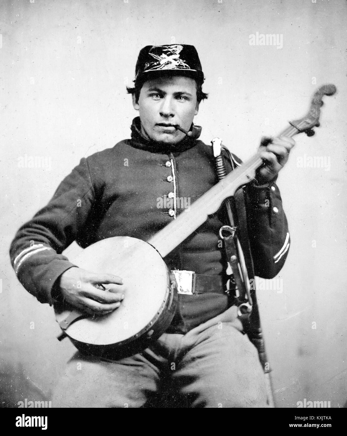 Soldier in Union cavalry uniform with banjo, sword, and pipe. c.1861 Stock Photo