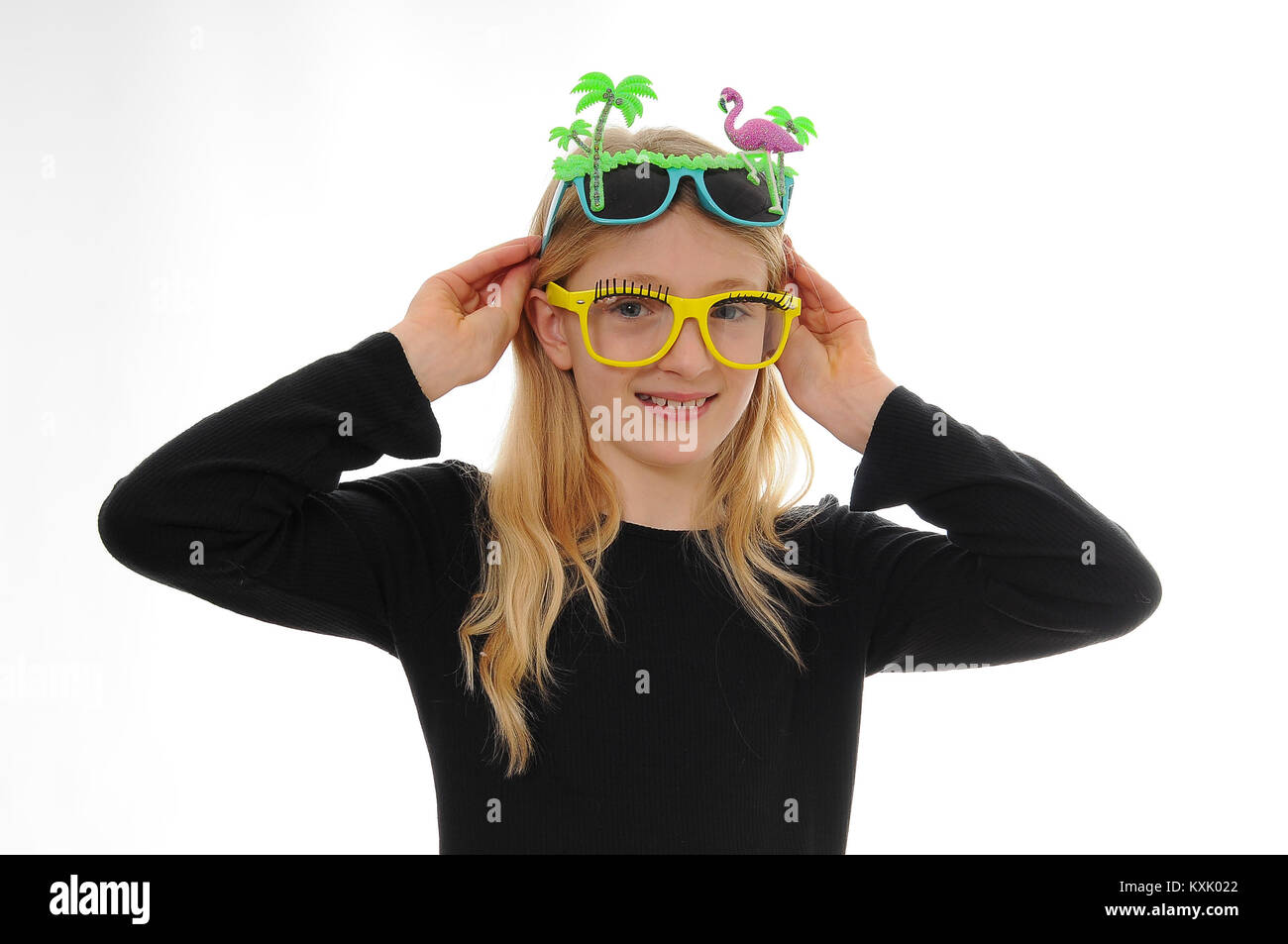 pretty blonde Caucasian girl, dressing up wearing two pairs of fun glasses, isolated on white Stock Photo