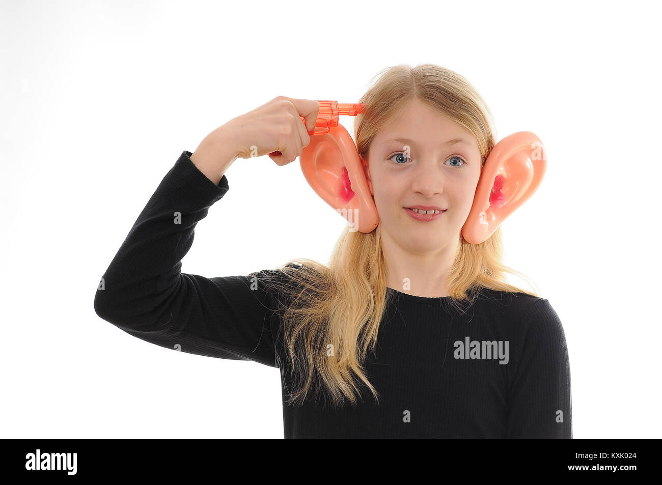 pretty blonde Caucasian girl with large, false ears, shooting herself with a plastic water pistol, isolated on white Stock Photo