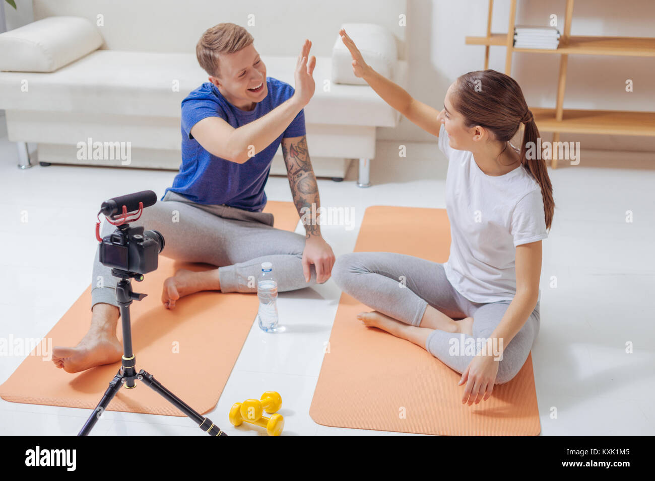 Happy emotional bloggers giving each other five and smiling Stock Photo ...