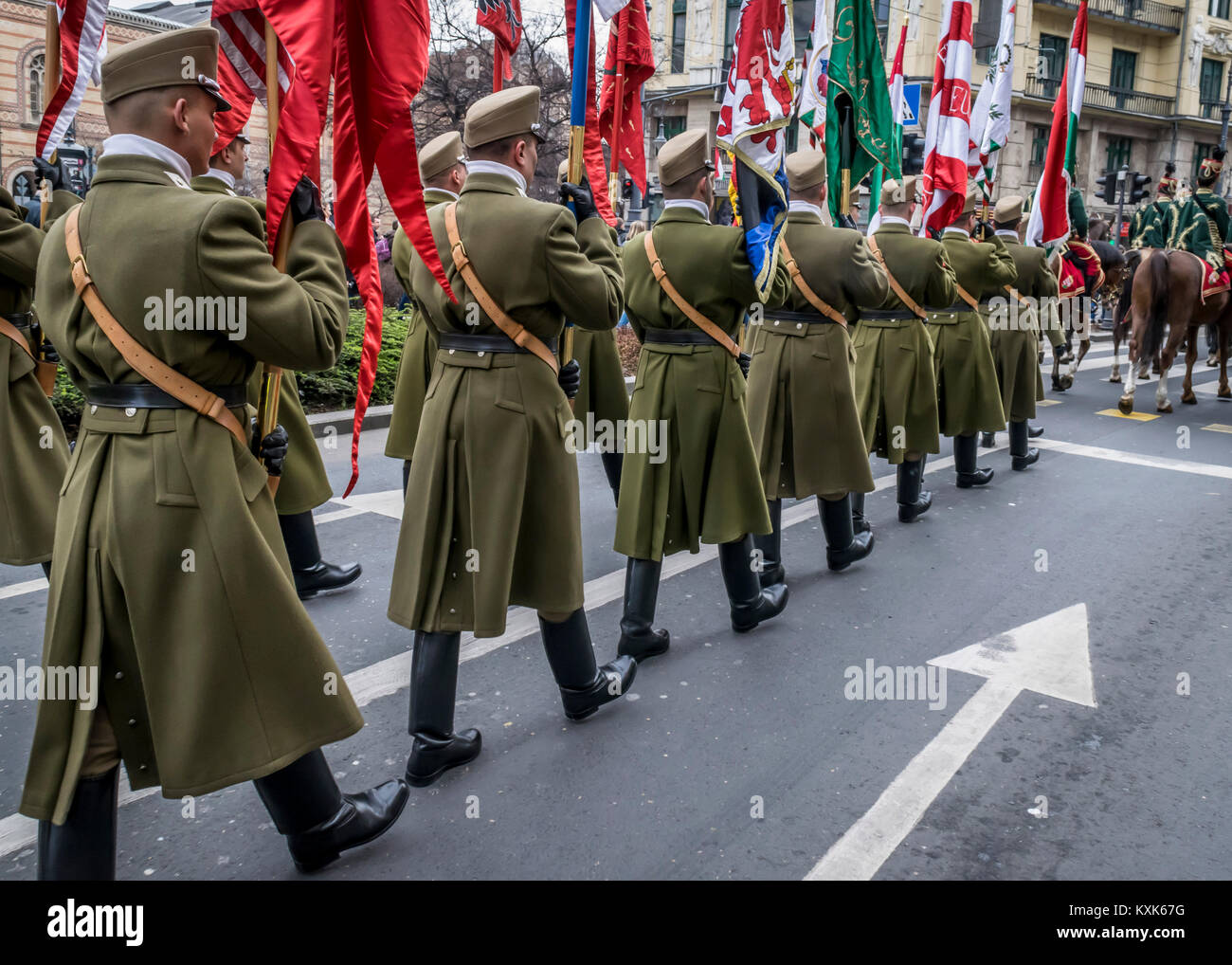 Procession of Hussars on horses and soldiers marching during the 15 March parade in Budapest, Hungary. Military parade on Hungarian National Holiday. Stock Photo