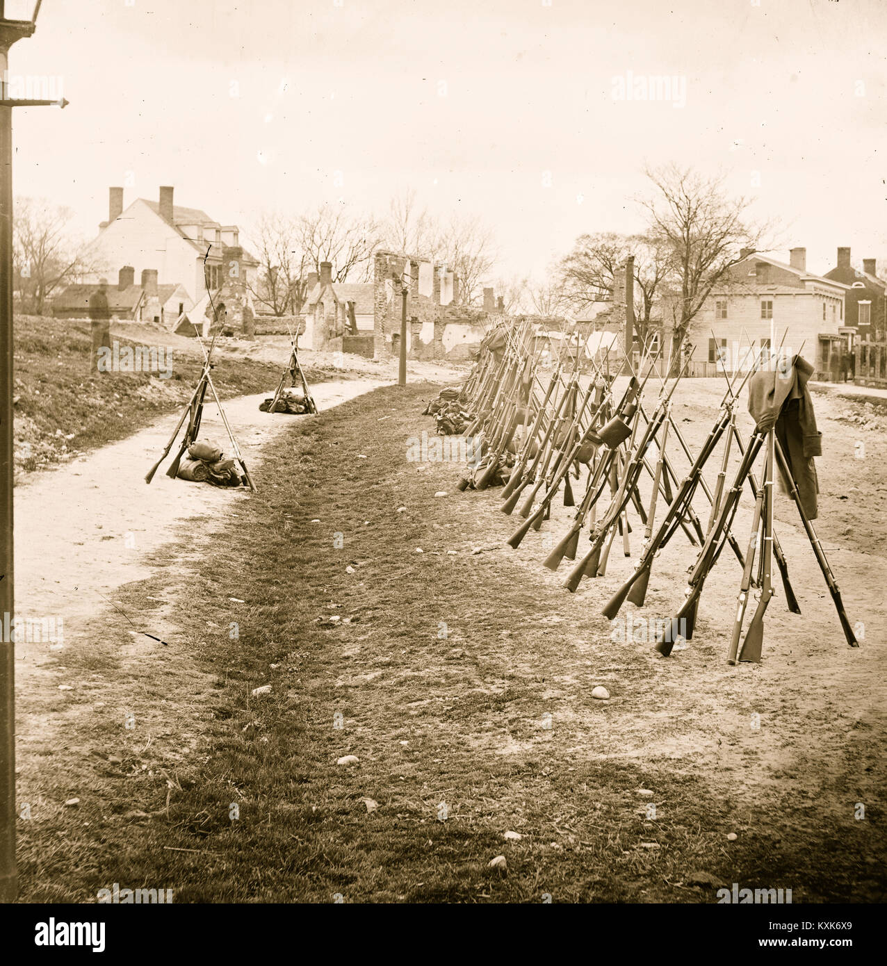 Petersburg, Va. Row of stacked Federal rifles; houses beyond Stock Photo