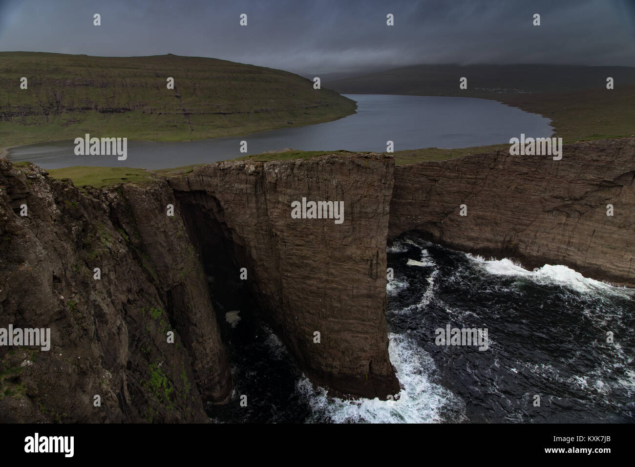 Leitisvatn lake with cliffs dropping into the atlantic sea in Faroe Islands Stock Photo