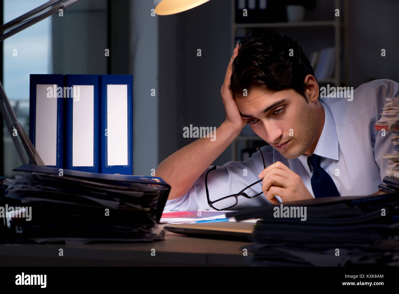 Young businessman working overtime late in office Stock Photo - Alamy